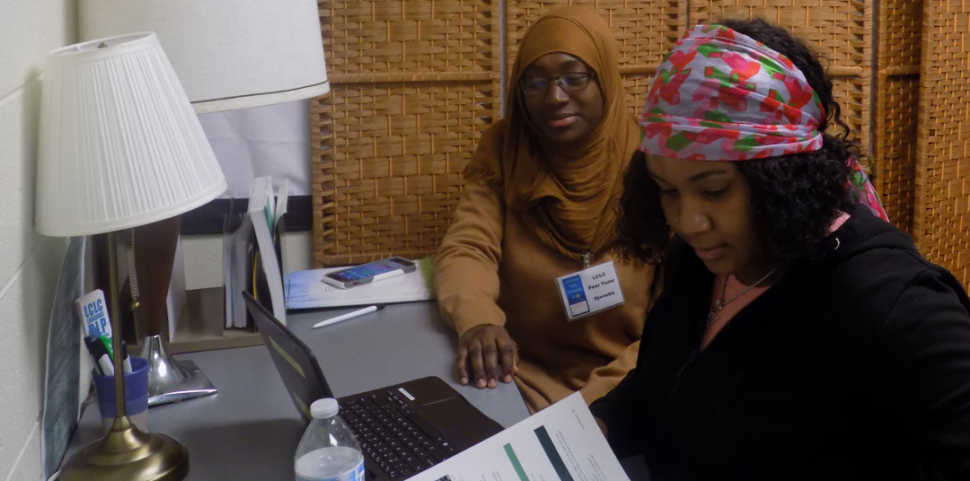 Former French peer tutor and UIC graduate Djeneba (left) working with a student (right)